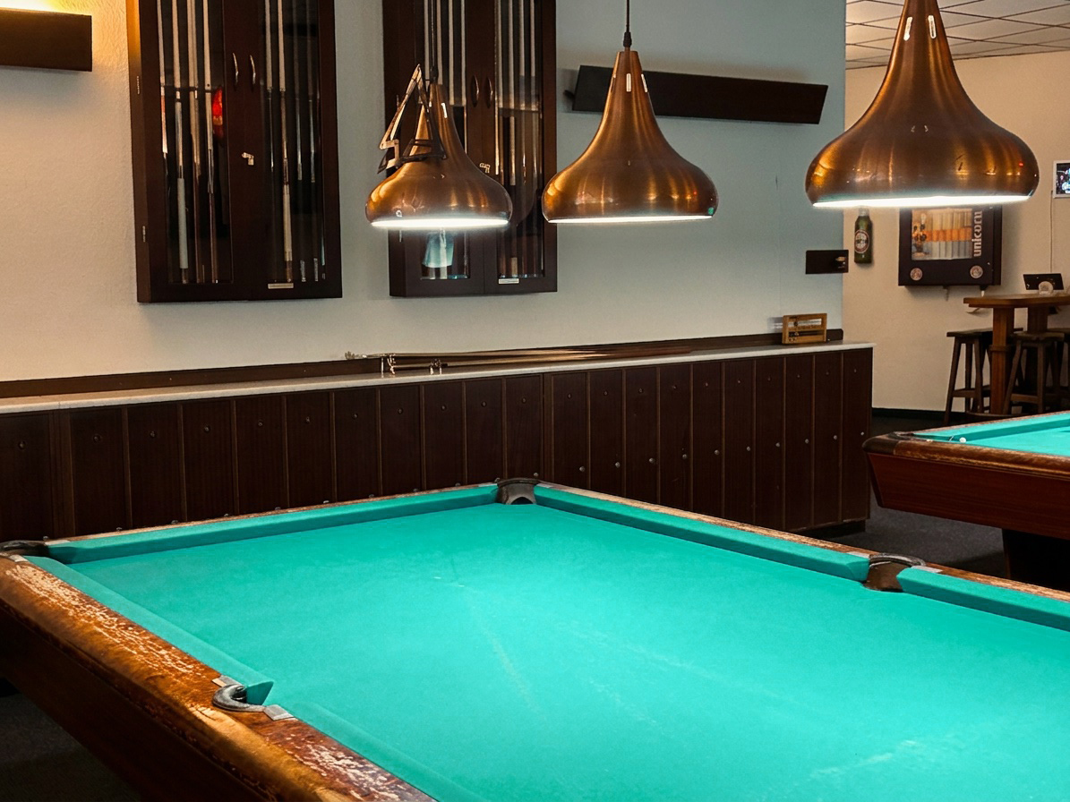 Pool tables under copper lamps